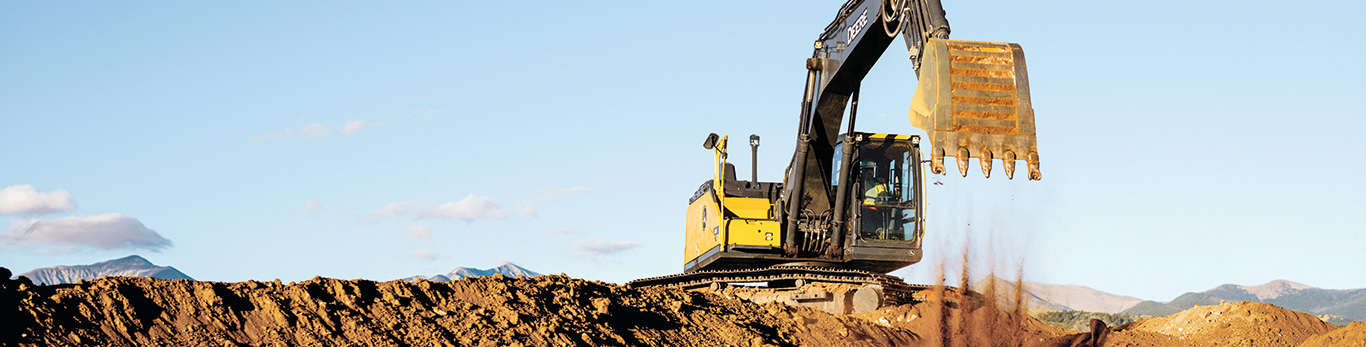 John Deere excavator dumping dirt on a construction jobsite