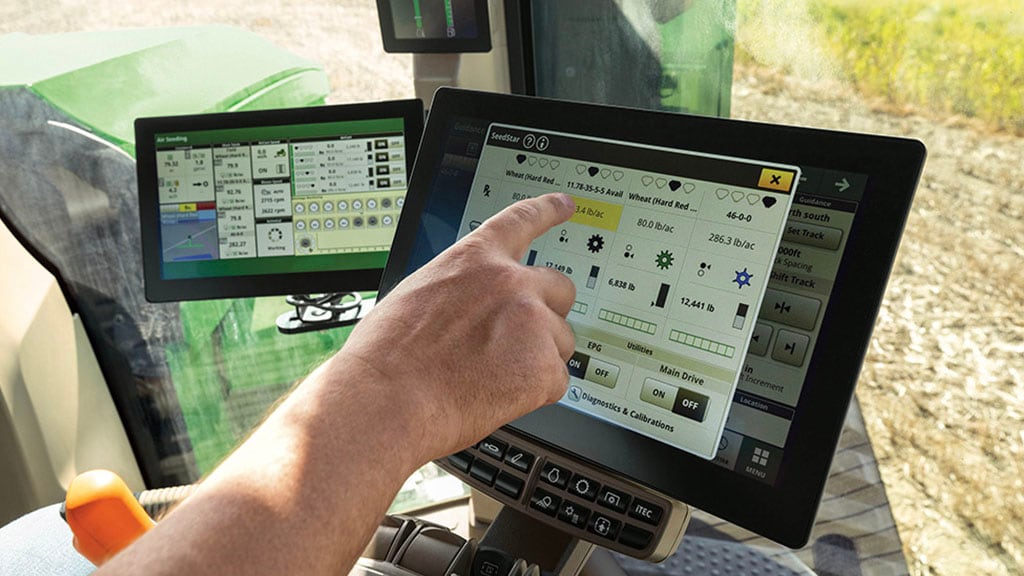 hand with pointer finger navigating touch-screen in a tractor cab