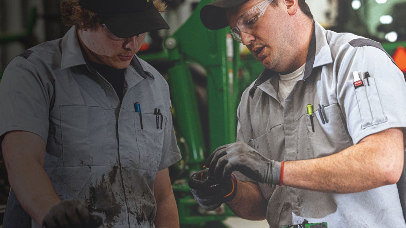Two men working together analyzing a part that came in for service