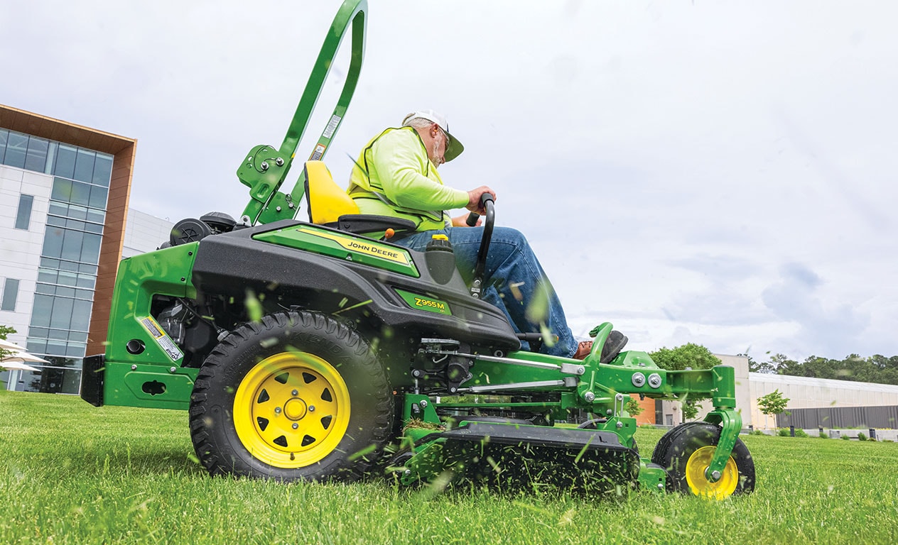 Older person mowing an office's lawn with a mower