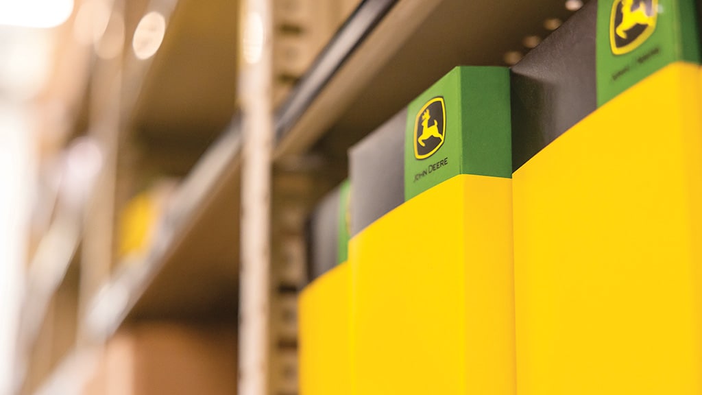 John Deere part boxes on the shelves of a dealership store room.