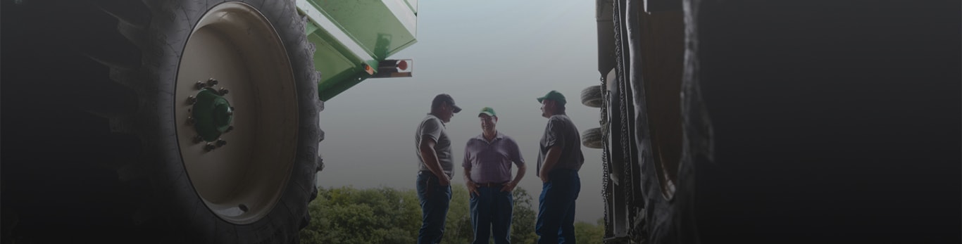 Three men having a conversation in a field