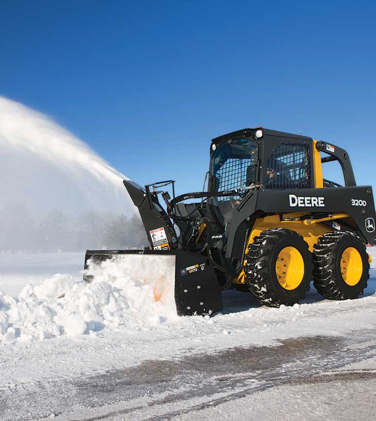 Compact equipment being used to blow snow