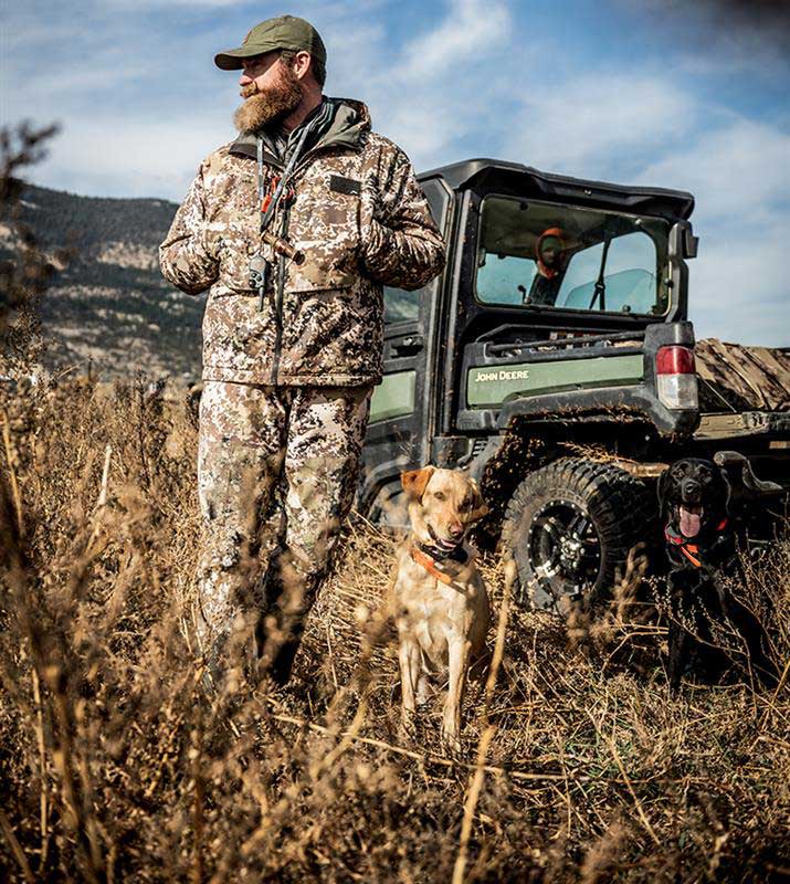 Gator XUV835R in field with man in camouflage clothing and a dog