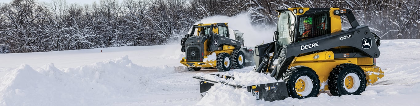 The 330 P-Tier Skid Steer with the Snow Pusher SP10C and the 334 P-Tier Skid Steer with the Snow Blower SB84S