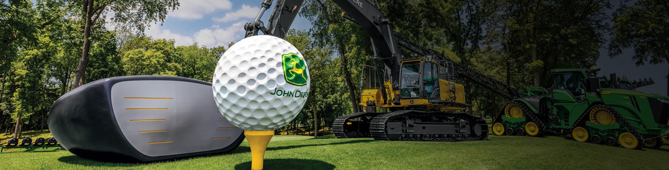 Giant golf ball in front of John Deere construction and ag equipment