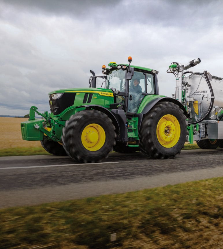 Tractor driving on road with slurry tank attached