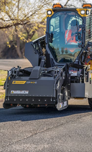 a 334 P-Tier Skid Steer is using a CP40G cold planer on a street