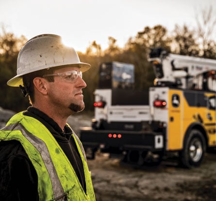 A John Deere field service technician looking in the distance.