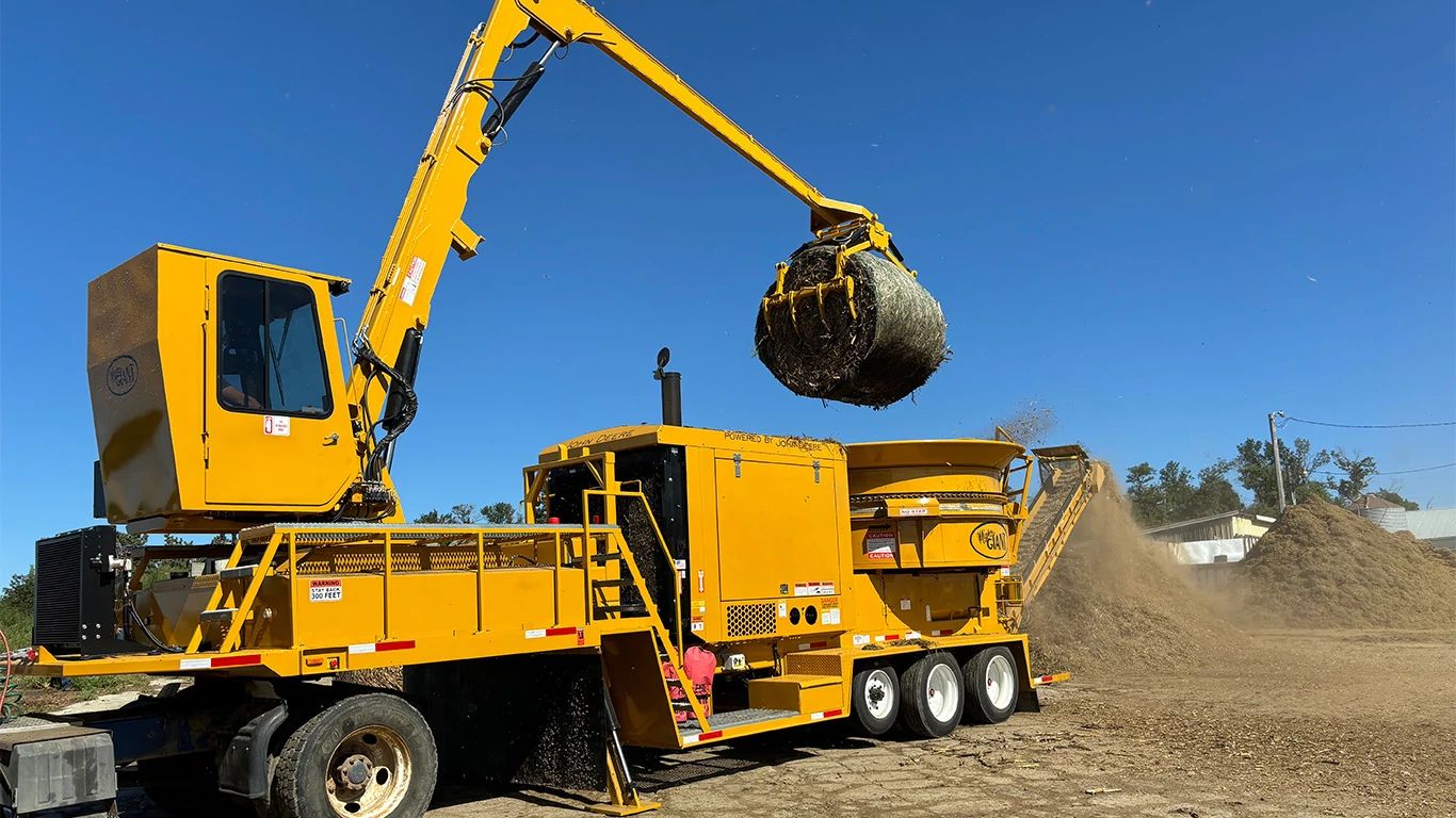 A Mighty Giant hay grinder powered by a John Deere JD18 industrial engine processing bales of hay