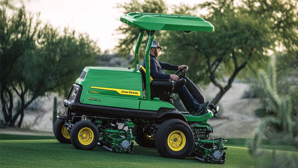 A person driving a 7700A E-Cut™ Hybrid Fairway Mower on golf course