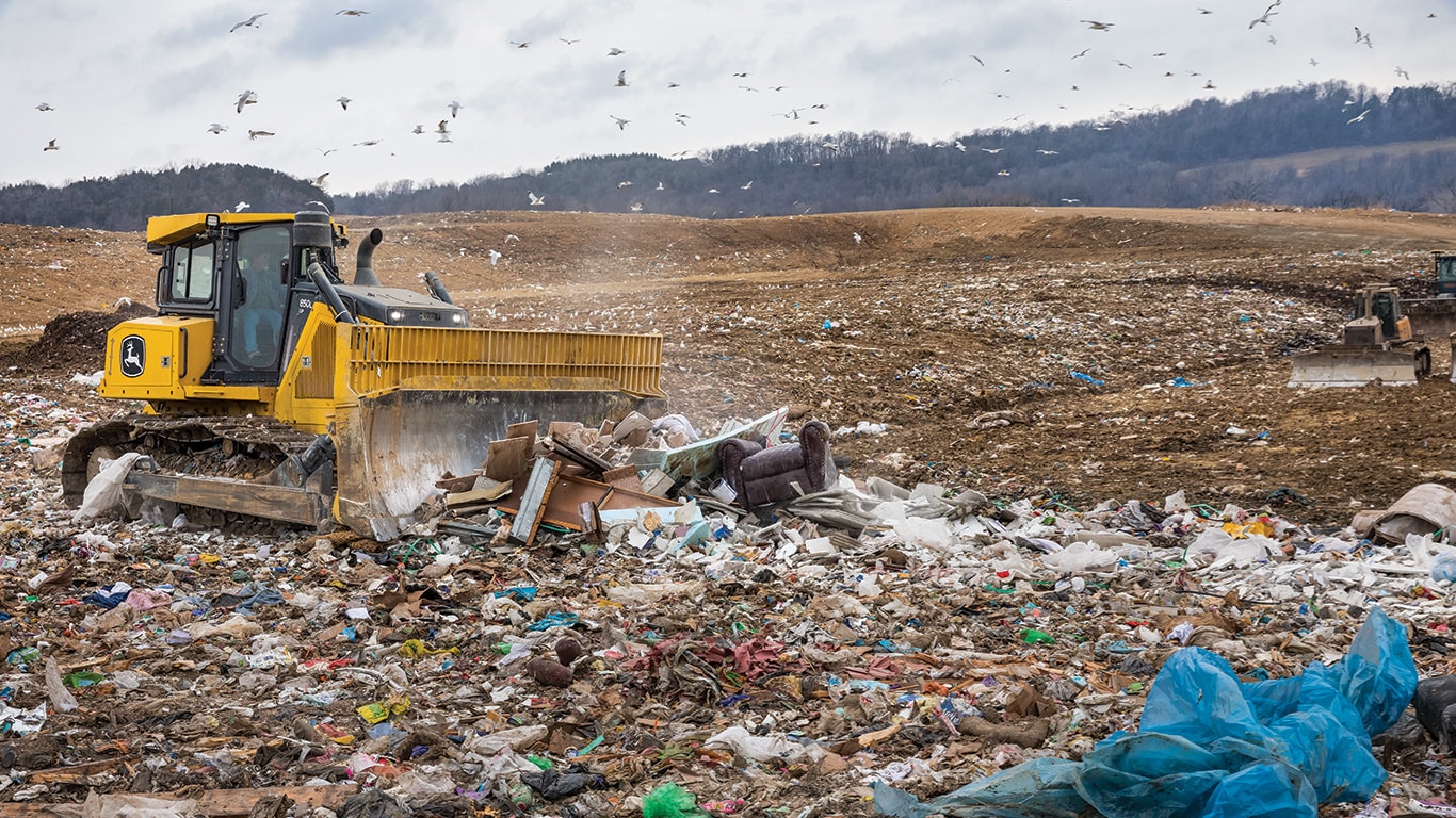 A John Deere 850 L-Tier Crawler Dozer pushes waste in a landfill.