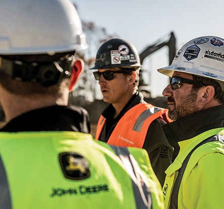 A team of construction workers gathers to discuss the day's objective.