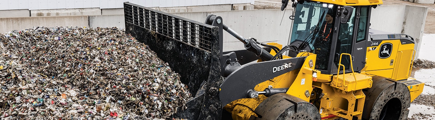 A John Deere 644 X-Tier Wheel Loader pushes a pile of recycled aluminum.