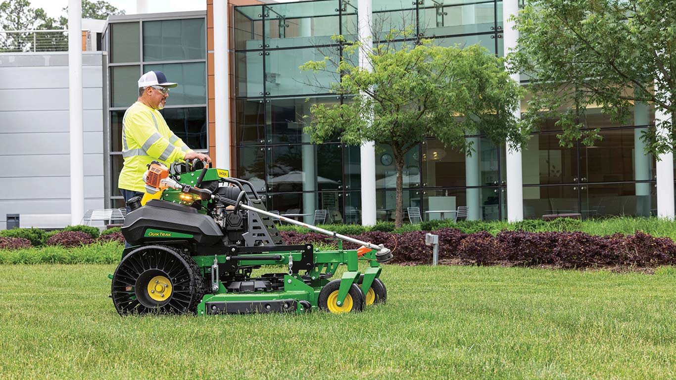 Side-shot of a QuikTrak mower in front of a corporate building