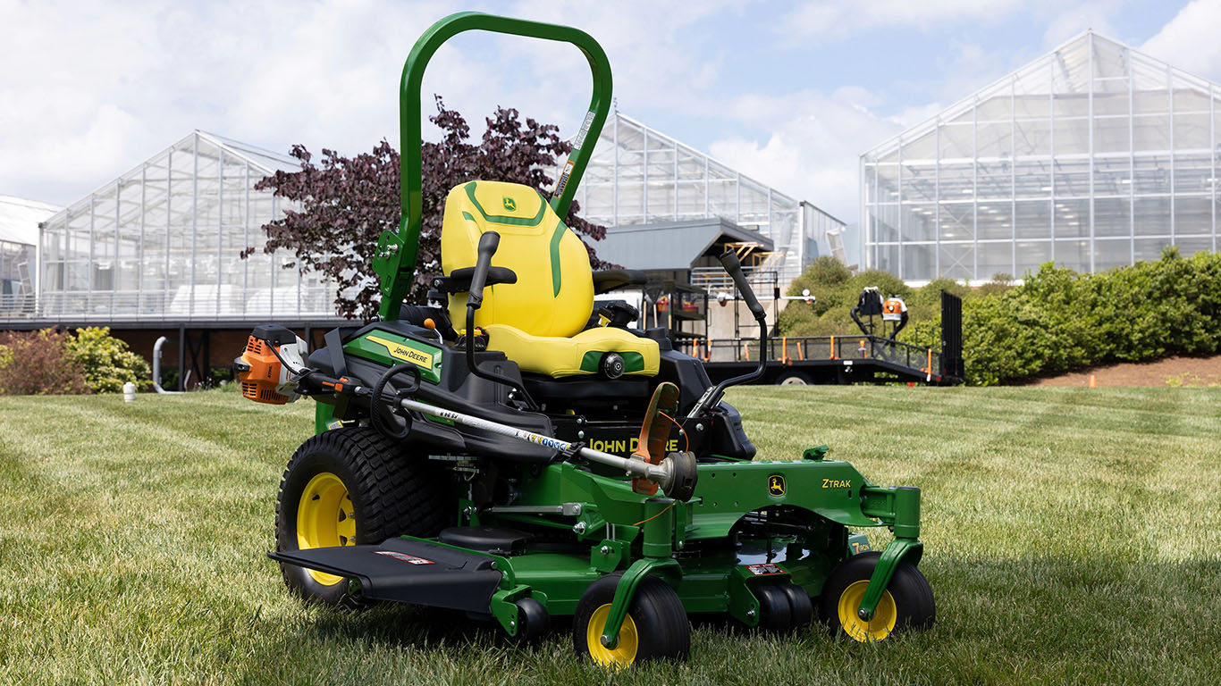 John Deere Z900 EFI Mower with weed wacker in front of a building