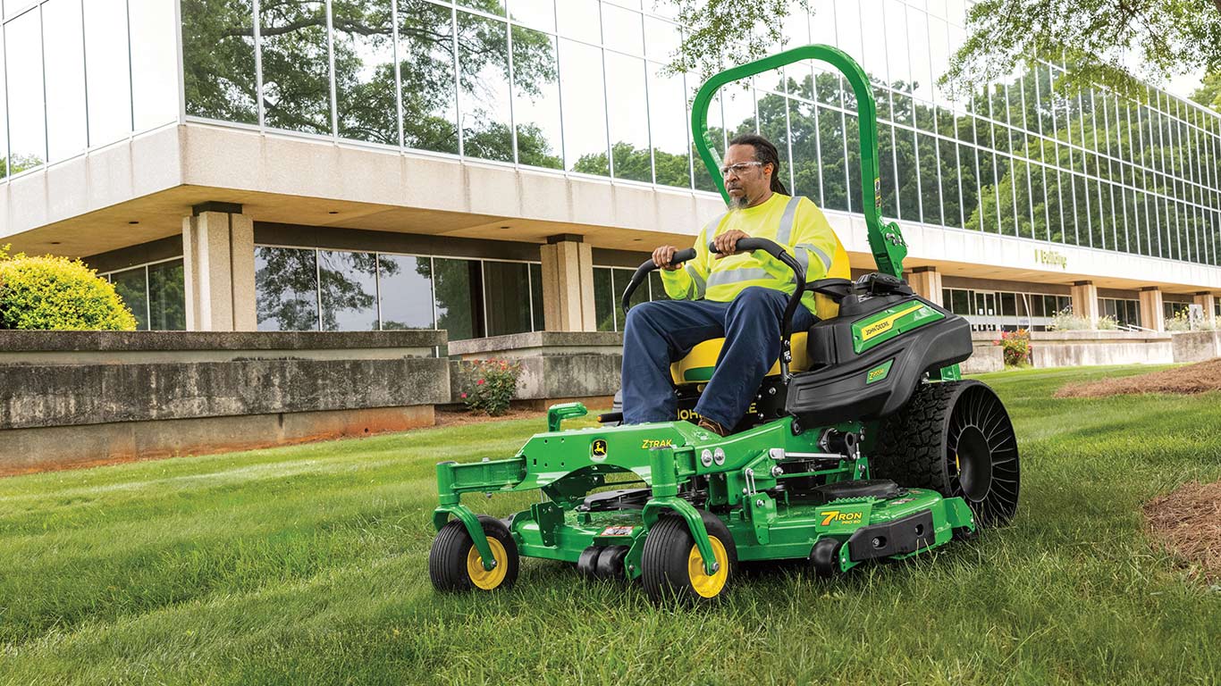 Operator riding on the new Z955M EFI in front of a glass building