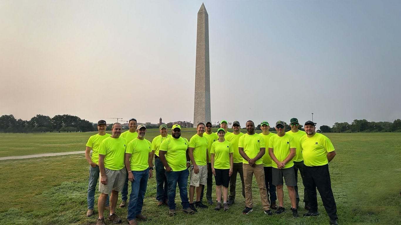 A large group of people pose in front of the Washington Monument