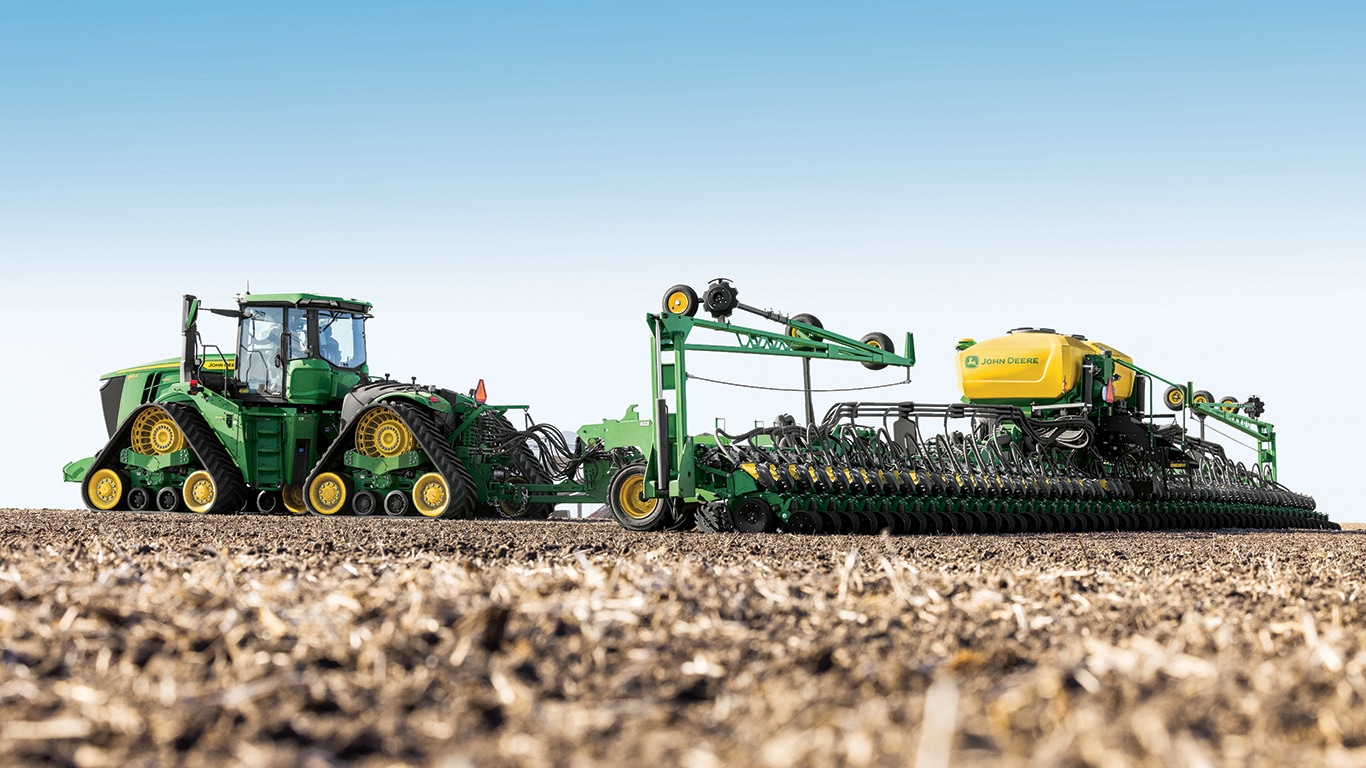 9RX tractor pulling planter through the field.