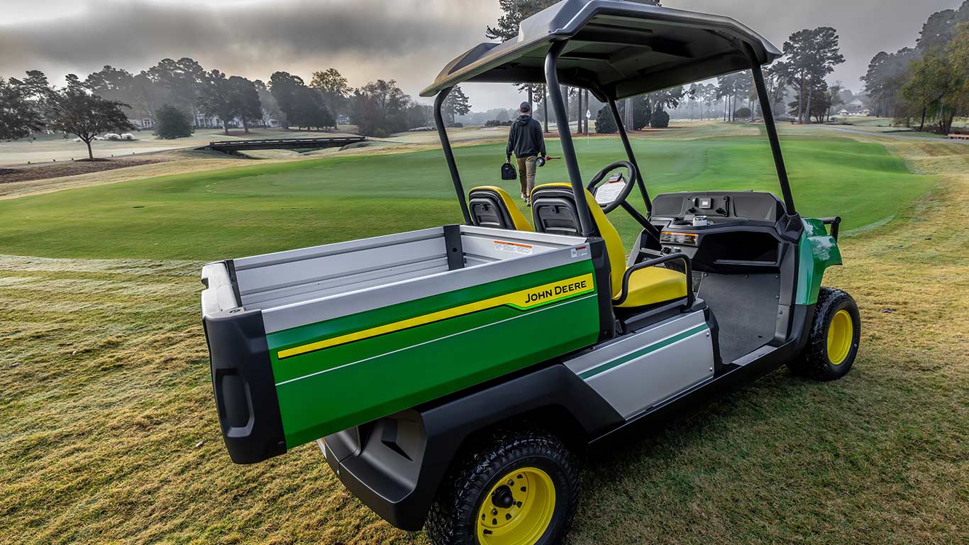 Back side view of the Gator™ GS Electric with a worker walking away.