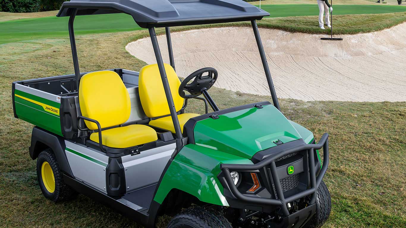 Electric gator next to sand trap on golf course.