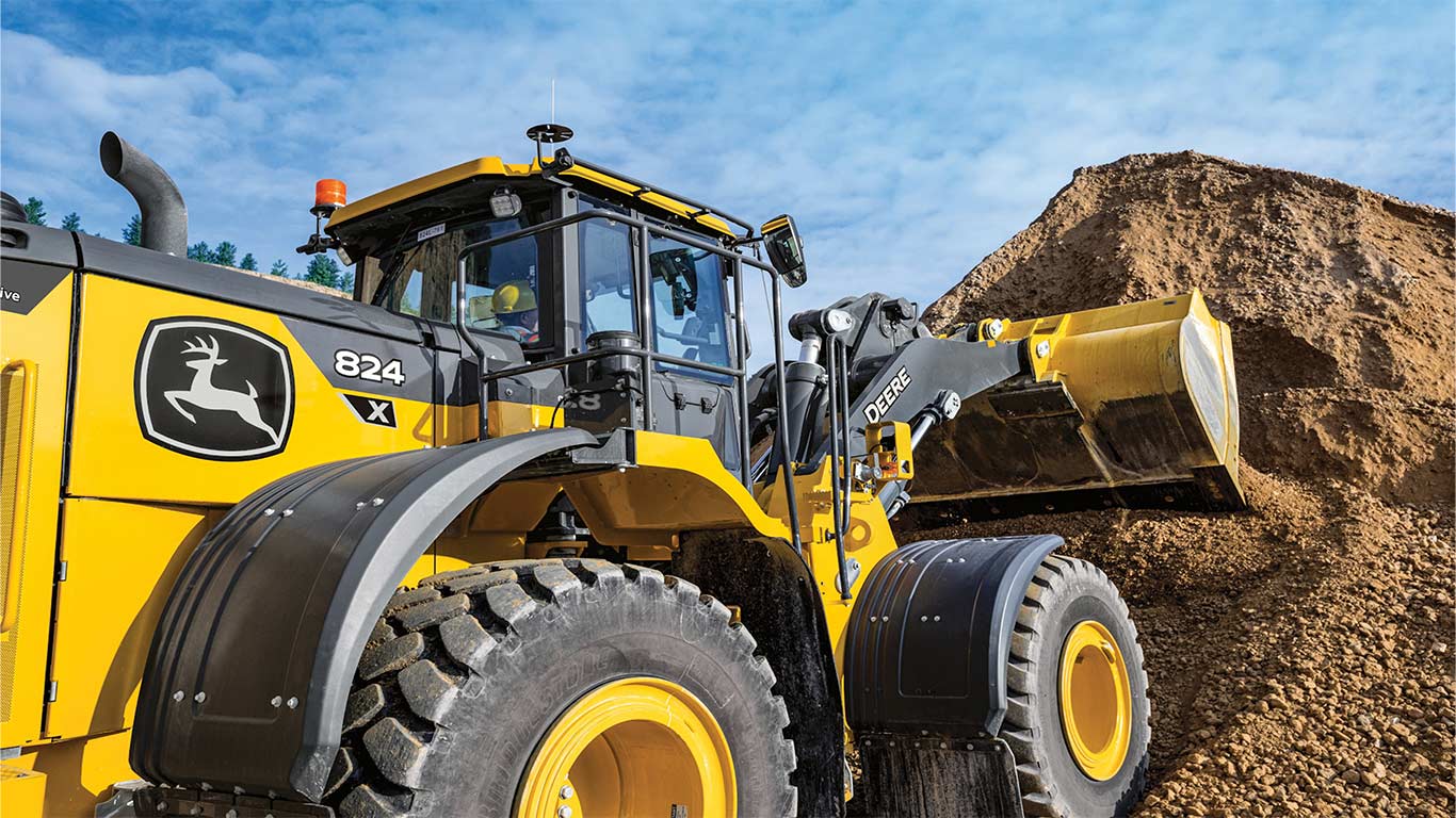 The 824 X-Tier Wheel Loader with SmartDetect Digital scooping dirt