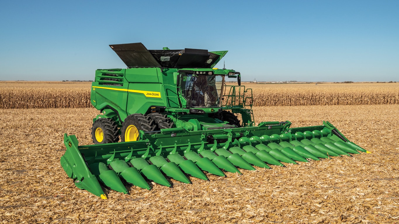 X9 combine with corn head parked in corn field