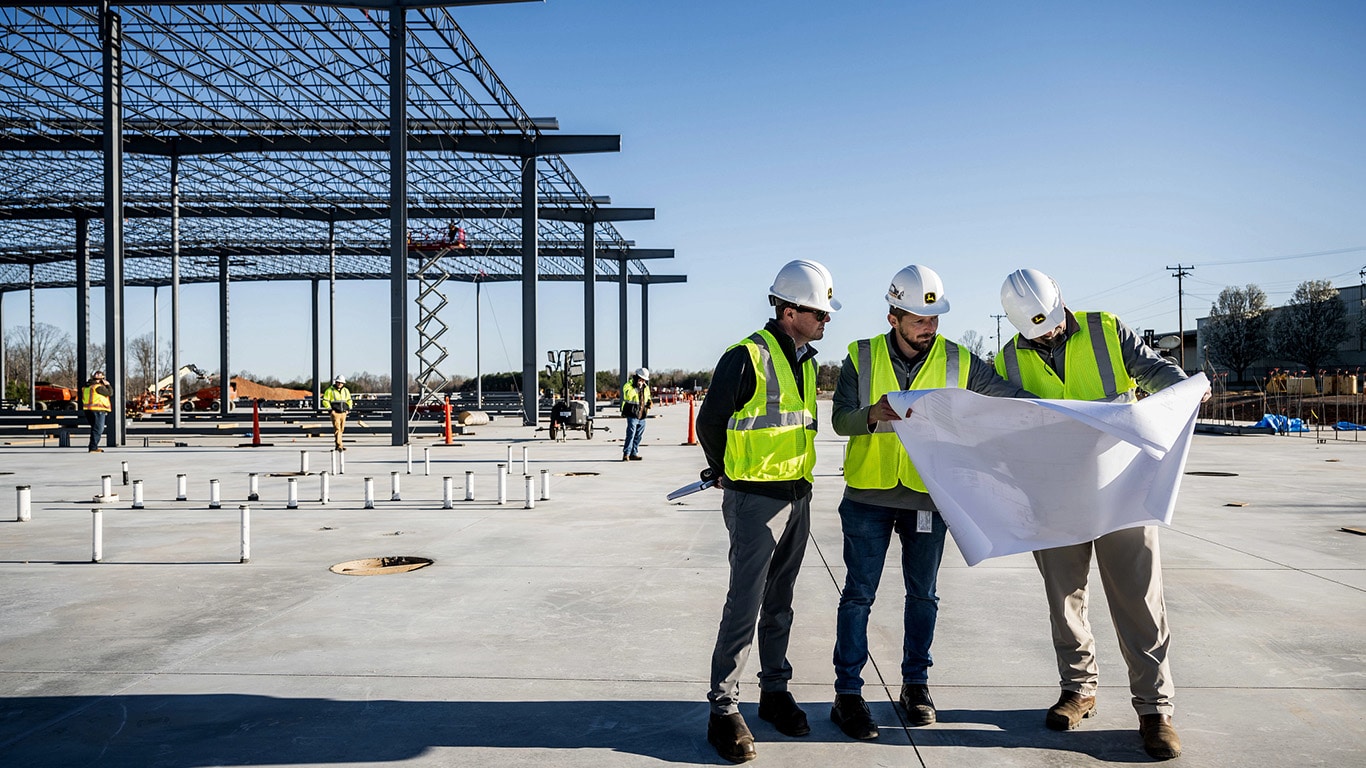 Construction teams look at blueprints for the expanded Kernersville, North Carolina excavator factory
