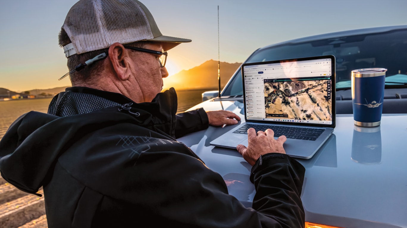 Researcher on computer by his pick-up truck