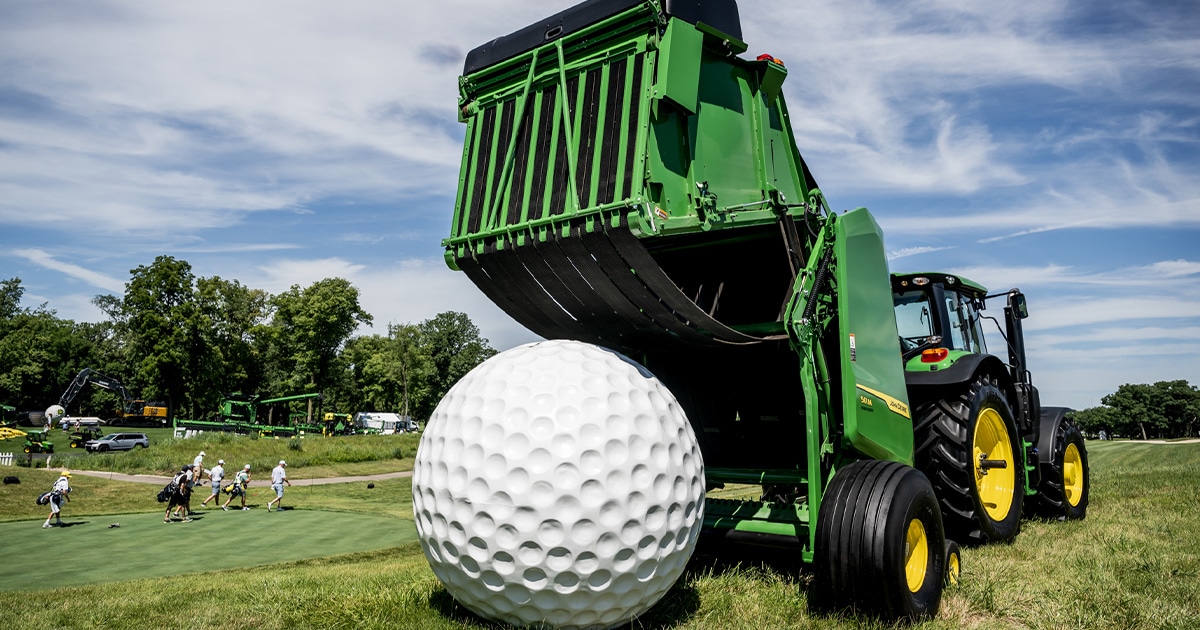 A giant golf ball in front of John Deere equipment on the greens at the John Deere Classic