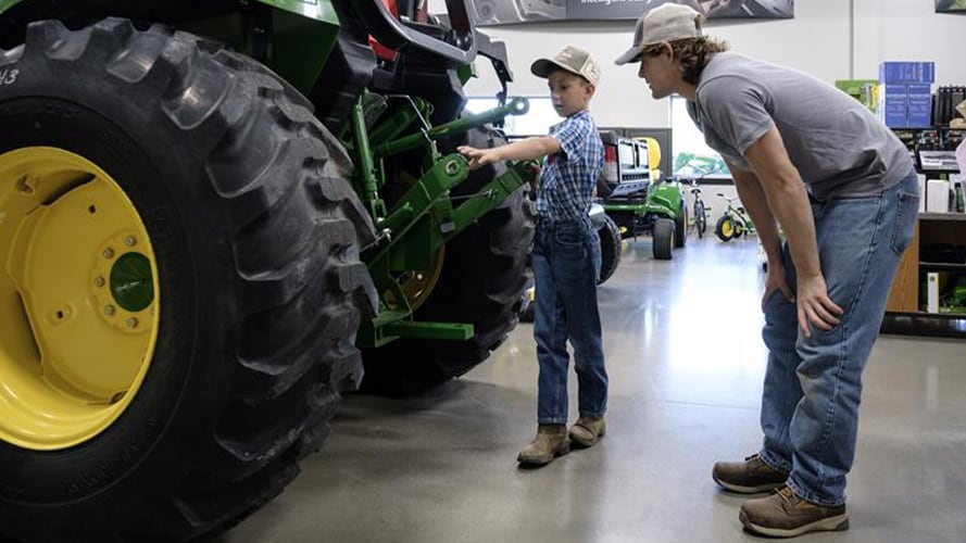 Jackson and Rex examine a John Deere tractor together