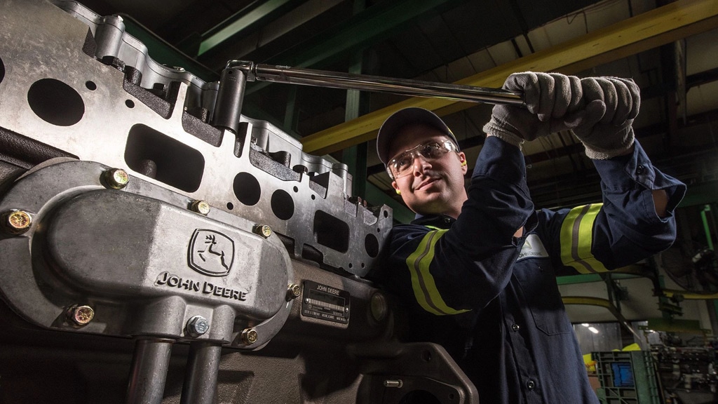 a service technician using wrench on engine