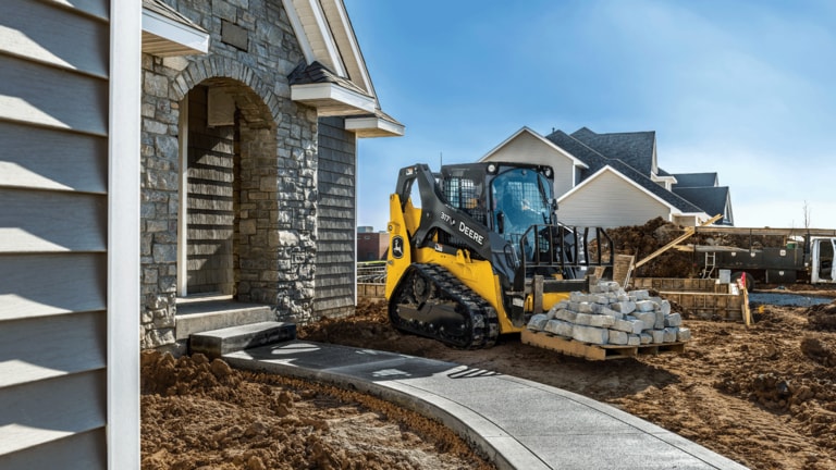 317 P-Tier compact track loader moving pallet of stone for landscaping around house. (2nd thumbnail)