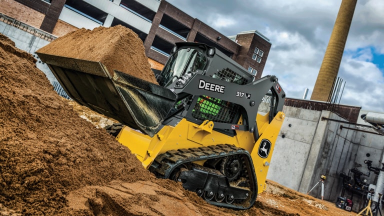317 P-Tier compact track loader using bucket attachment to move sand on job site. (5th thumbnail)