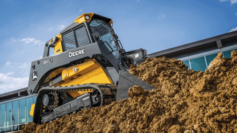 331 P-Tier compact track loader driving onto hill of dirt and using bucket to move dirt. (2nd thumbnail)