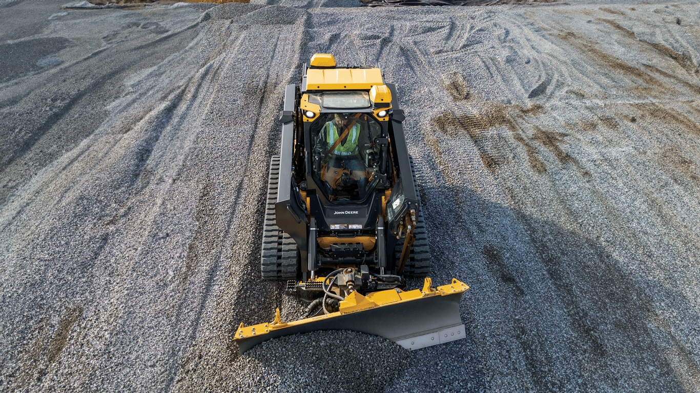 335 P-Tier compact track loader viewed from the top moving gravel with blade.