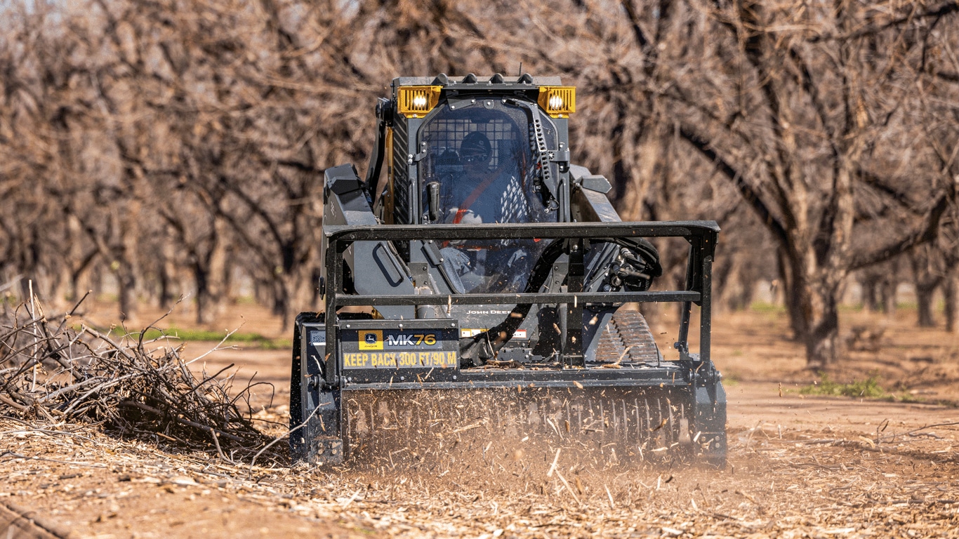 335 P-Tier compact track loader using MK76 mulching head to clear brush and tree trimmings.