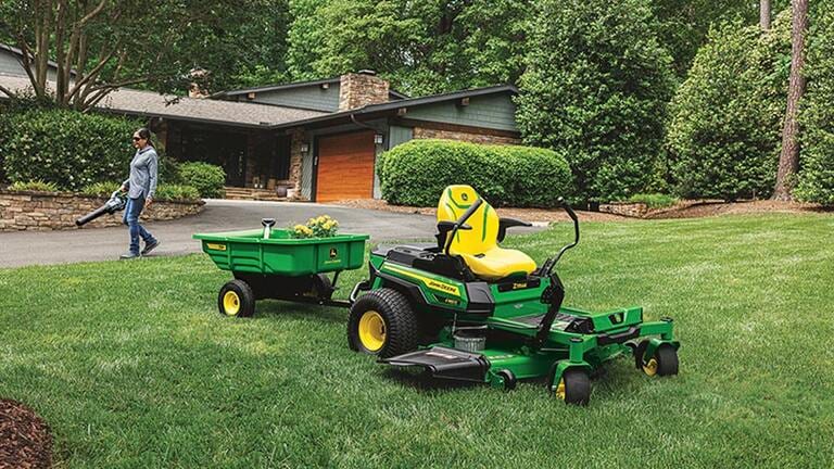 Person blowing grass with a Z380R, with 7P car attached, in the foreground