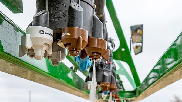 Close-up photograph of an ExactApply Precision Upgrade nozzle spraying.