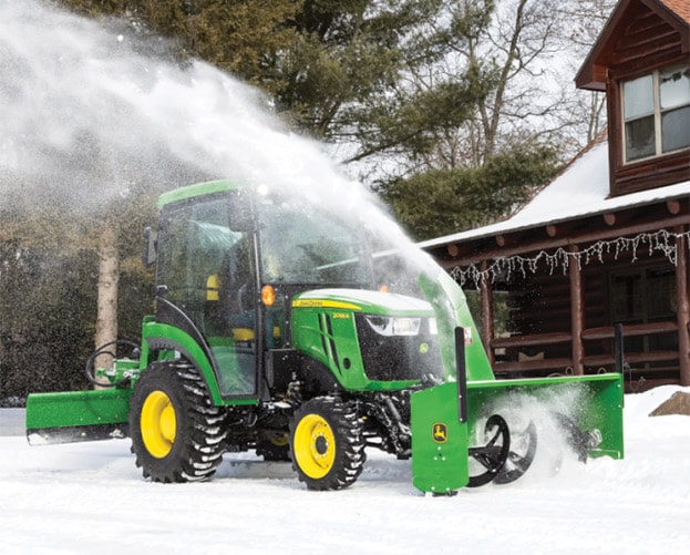 green and yellow tractor blowing snow