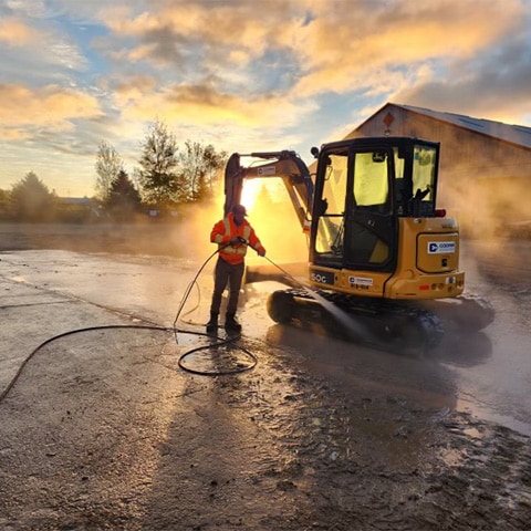 A John Deere 50G-Tier Mini Excavator being cleaned off after a days work.