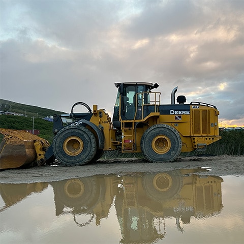 A John Deere 824K-Tier Wheel Loader digs into a pile of dirt.