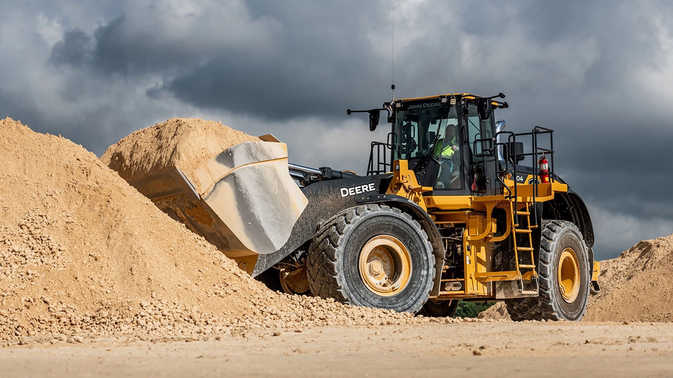 A John&nbsp;Deere 904 P-Tier effortlessly lifts a full bucket of gravel.