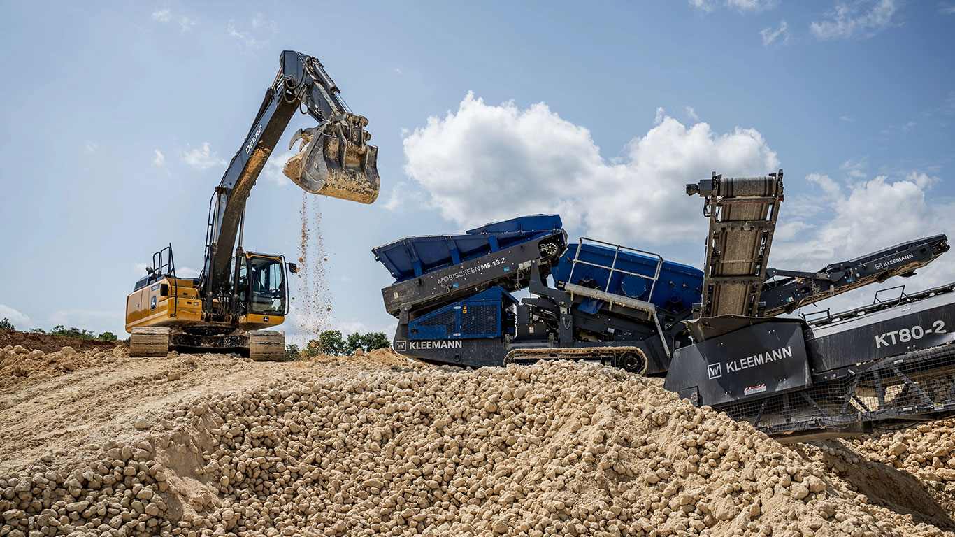 The John&nbsp;Deere 250G LC Excavator lifts a bucket of rocks to be fed to the Kleeman Mobiscreens MS 13 Z.