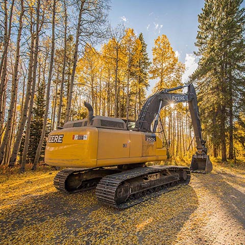 John Deere 250G Excavator parked in the woods