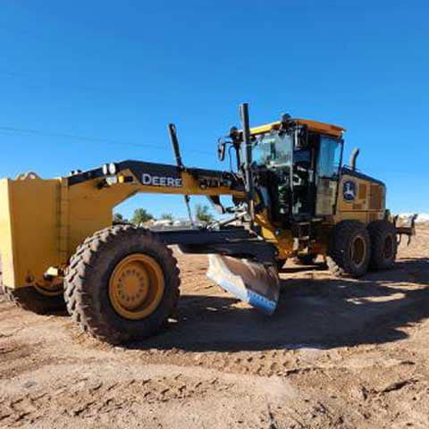 A John Deere motor grader on a jobsite