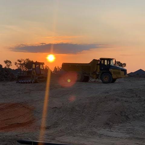 Sunset behind a Deere dozer and ADT