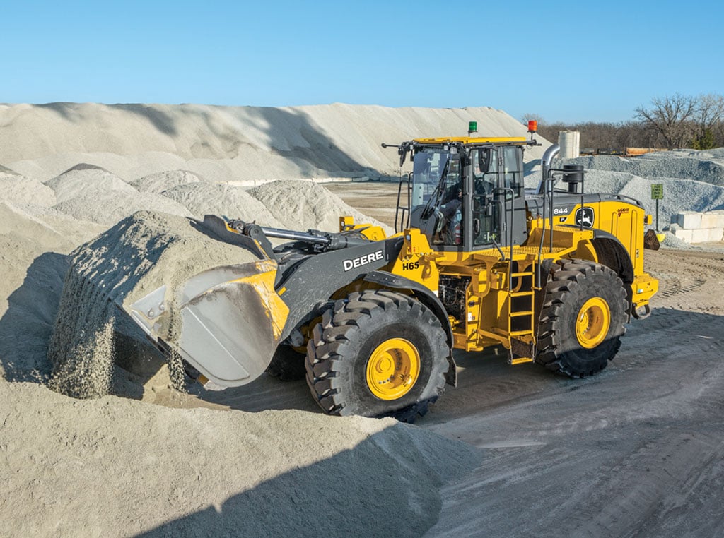 A wheel loader lifting gravel from a large pile