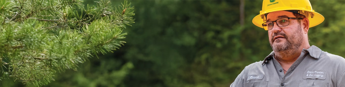 Frank Trexler stands in front of trees and explains the focus of Trexler & Sons is to try to maximize  production while minimizing fuel use and machine wear.