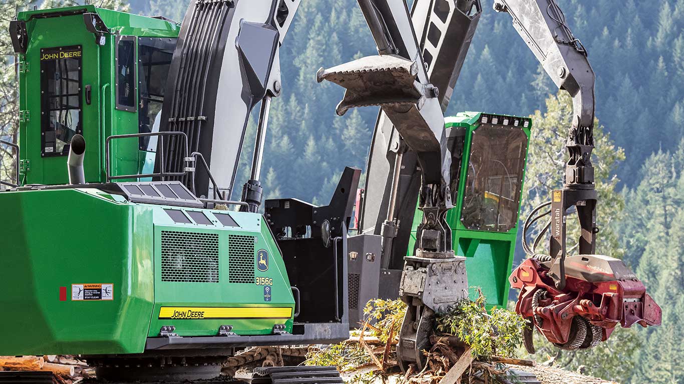 A set of John Deere 3156G Swing Machines equipped with a claw and Waratah HTH624-C head collect logs.